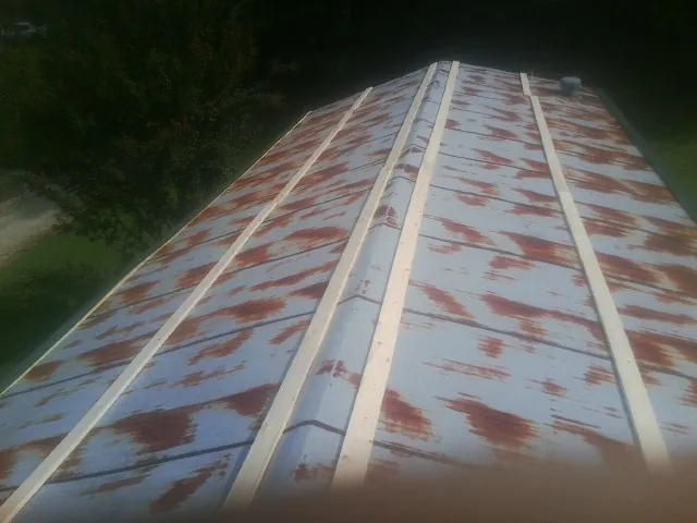Rusted metal roof panels with new wood purlins before replacement — Storm Damage Roof Repair in Spencer by Roofing Brothers