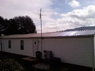 New metal roof on a single wide mobile home with a TV antenna in Spencer